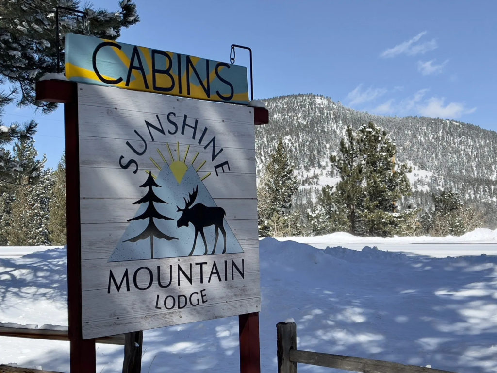 Sunshine Mountain Lodge sign in snow