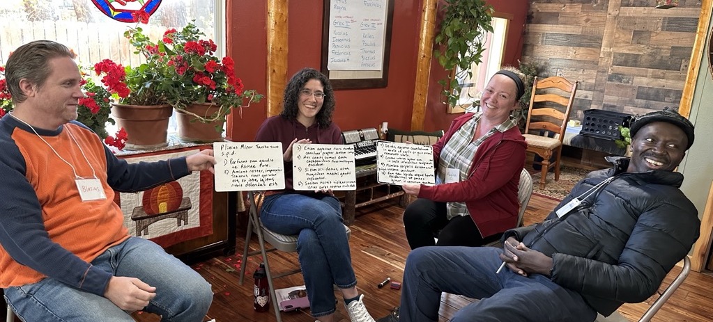 Participants at Biduum Coloratanum smile as they show off Latin exercises written on small white boards
